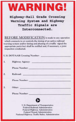 Figure 9.  Image.  Field Example Warning Label.  Warning label sponsored by the U.S. Department of Transportation, Federal Railroad Administration, Federal Highway Administration, Federal Transit Administration, and National Highway Traffic Safety Administration.  Label alerts highway agency and railroad personnel of the interconnection between the two systems.  The label also includes areas to provide contact information for the responsible highway agency and railroad.