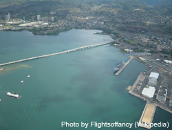 Aerial image looking northward of part of Pearl Harbor showing the USS Arizona (note oil slick), USS Bowfin and museum, Aloha Stadium, Admiral Clarey Bridge, some of the naval facilitates, and O'ahu's terrain.