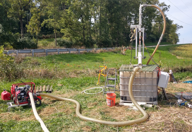 "PSTD in the field, including the linear drive mounted over the water tank and the hoses connecting the system to the smaller portable pump."