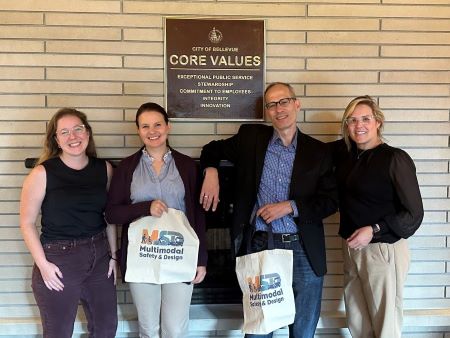 Group of four staff members from the City of Houston and City of Bellevue standing in front of signed read “City of Bellevue Core Values”