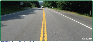 "The approach to a curve featuring curve warning signage and edge line rumble strips"