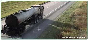 "A tanker truck traveling along the edge of a roadway applying a fog seal to the edgeline rumble strip."