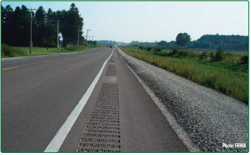 "Bicyclist riding over gravel and debris on the narrow shoulder of a roadway as cars pass. Source: FHWA"