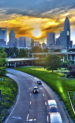 a highway on the outskirts of a large city at sunset