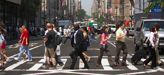 "busy pedestrian crosswalk on a multi-lane, one-way city street"