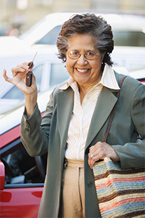 "older woman smiling and holding up her car keys"