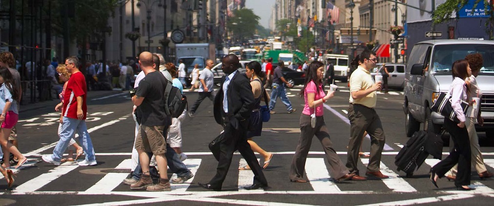 "a busy city crosswalk filled with pedestrians"