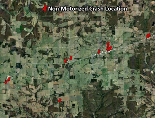 "Graphic.  A graphic of a pushpin map.  The pushpin map is an aerial photograph of the region studied.  There are red pushpins indicating the location of non-motorized crashes."