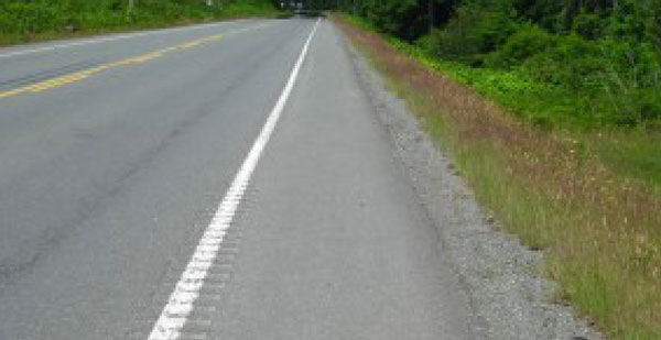 "Photo.  A photo of a rumble stripe, which is a narrow rumble strip that is overtop the roadway edgeline pavement marking that separates the travel lane from the shoulder.  "