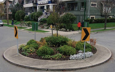 "Photo. A traffic circle with a landscaped circle in the center."