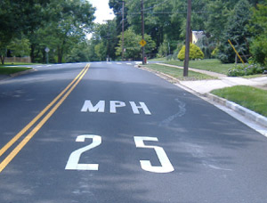 "Photo. A pavement marking of '25 MPH' to encourage speed reduction for an impending curve. "