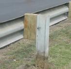 Strong post W-beam guardrail with wood block and metal post.
