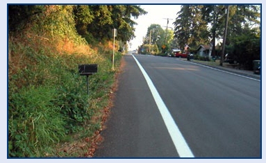 Photo of a rural roadway with a narrow shoulder.