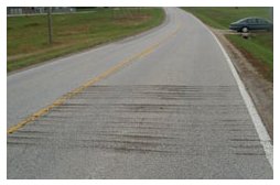 "Photo of a rural roadway with rumble strips cut into one of the travel lanes."