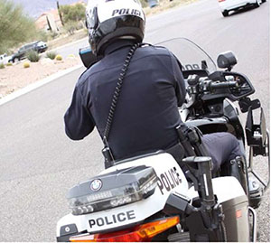 alt="Photo of HiVE enforcement using motorcycles. A police officer is depicted on a motorcycle observing traffic."