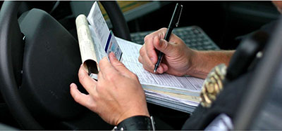 Photo of an Officer using driver information to complete a traffic ticket.