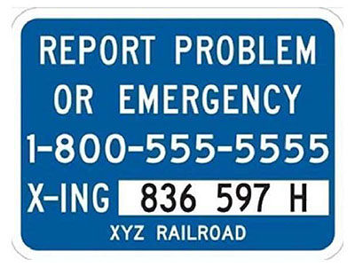 "Figure 13. Example of Emergency Notification Sign (ENS) - This is a blue sign that gives an 800 number for someone to call if they need to report a problem or an emergency. It also gives an alphabetical and numerical code for the crossing and a three lettered code for the railroad.)"