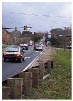 "Early morning photograph of a two-lane suburban road with non-flashing traffic lights"