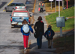 This sidewalk is not wide enough for all three children to walk side-by-side.