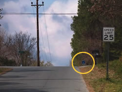 Pedestrians crossing the street to reach the bus stop circled in the photograph above will be hidden by the crest of the vertical curve.