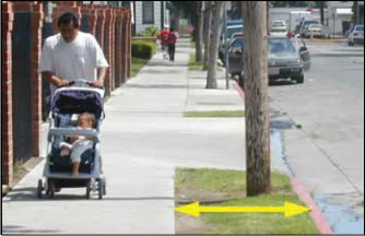 Photo: Man pushing scroller on paved walkway