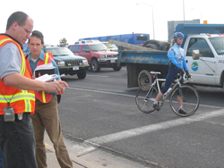 Road safety audit team observes various modes of transportation at an intersection"