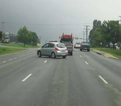 Vehicle turning out of uncontrolled access point onto US 29 northbound. The vehicle must cross 3 lanes of through traffic to get into the left-turn lane.