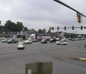 Intersection at Woodbrook Drive with dual left turn lanes and faded pavement markings.
