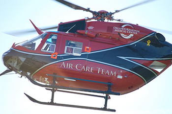 "Photograph of a hovering helicopter with the words 'Air Care Team' on the side"