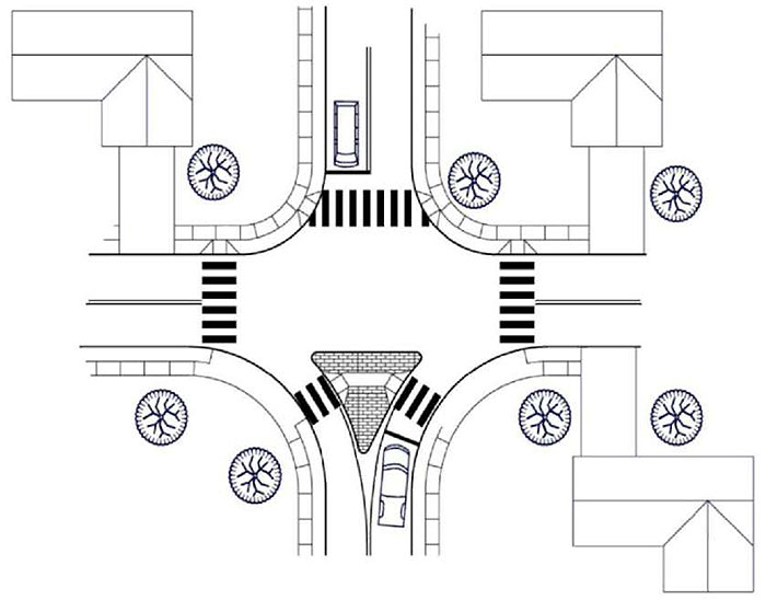 "Figure 3.24.2. Forced Turn Island Schematic. This figure contains a schematic of an intersection which uses a median island on the lower leg. This triangular island forces traffic in the right lane to turn right and prevents traffic in the left lane from crossing the intersection and entering the lower left lane. The other legs are free of any islands. A vehicle waits in the left lane of the upper leg."