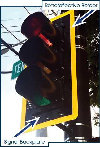 "A conventional traffic signal with a signal backplate and yellow retroreflective border.""