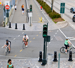 "Example of a safe intersection design showing bikes and pedestrians crossing a street"