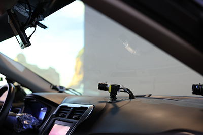 A camera mounted to a dashboard facing the driver in the driving simulator vehicle.