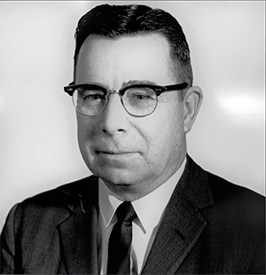 Historical black  and white photograph of Francis Turner—a middle aged white man with dark hair, rimmed glasses wearing a suit and tie.