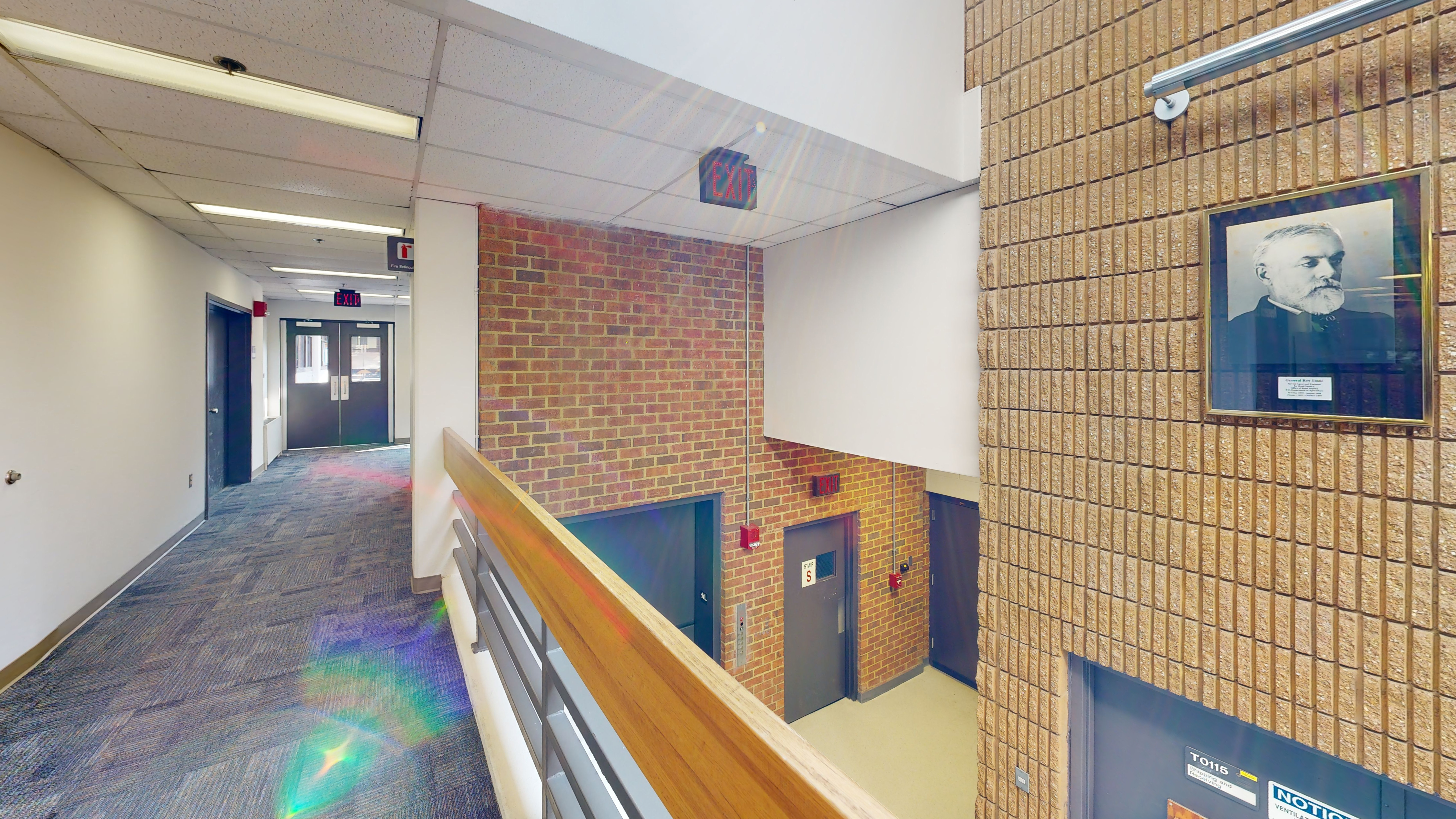 A hall leads to several doors near an overlook. 