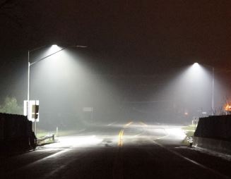 Streetlights illuminating a section of roadway at night.