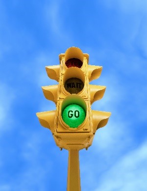 a modern traffic signal showing a green light at the bottom